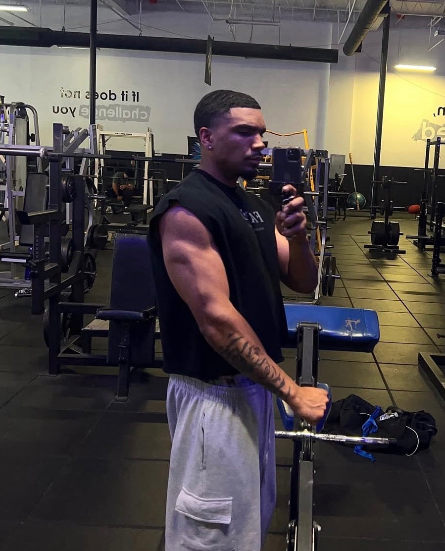 FAREO® Core Cut Sleeveless athletic tank top in black, shown on a hanger with front view and sleeveless design.