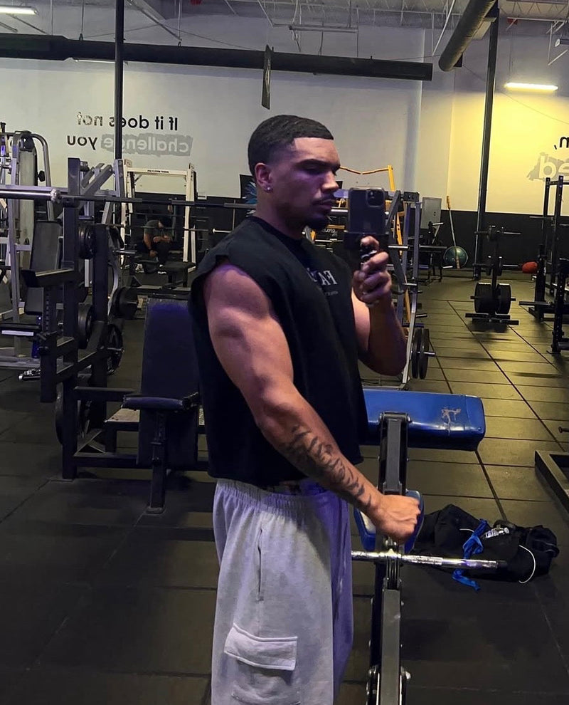 FAREO® Core Cut Sleeveless athletic tank top in black, shown on a hanger with front view and sleeveless design.